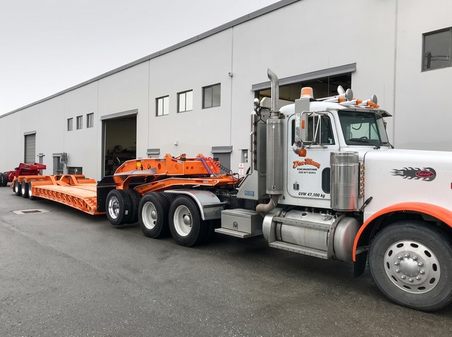 Orange lowbed and matching customer Peterbilt viewed from the front in the Pacesetter yard.