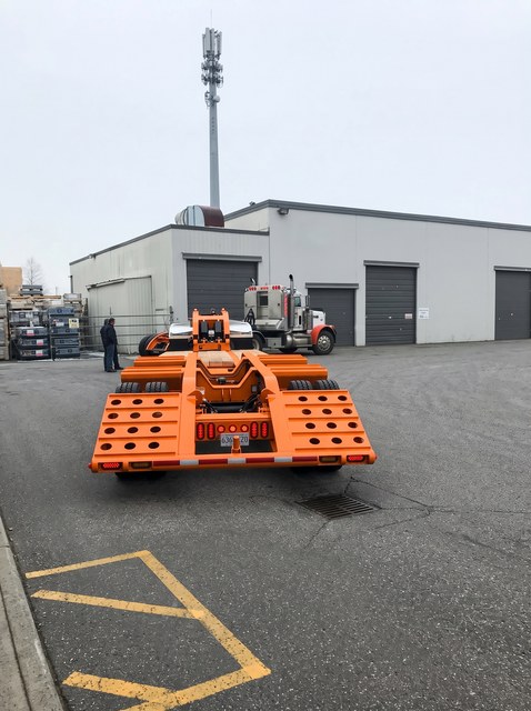 Rear view of the orange lowbed and its loading ramps.