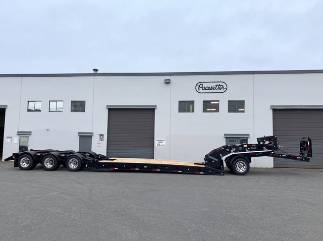 Side profile of the all-black lowbed, with a neck axle and three rear axles.