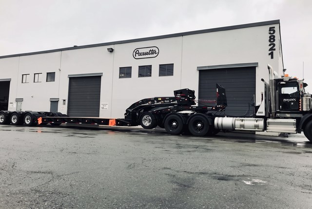 Side view of the all-black lowbed hitched to the customer tractor.