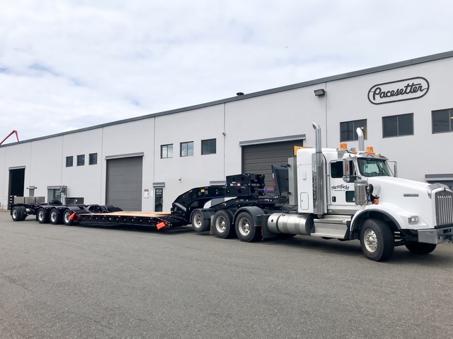 The black lowbed with blue trim behind the white customer tractor in Langley.
