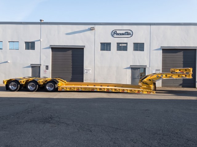 Full side profile of the yellow lowbed standing unhitched outside Pacesetter.