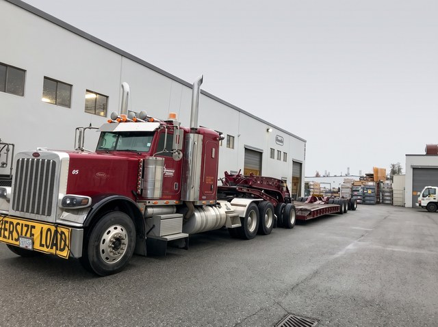 The matching burgundy customer Peterbilt and lowbed on pickup day in Langley.