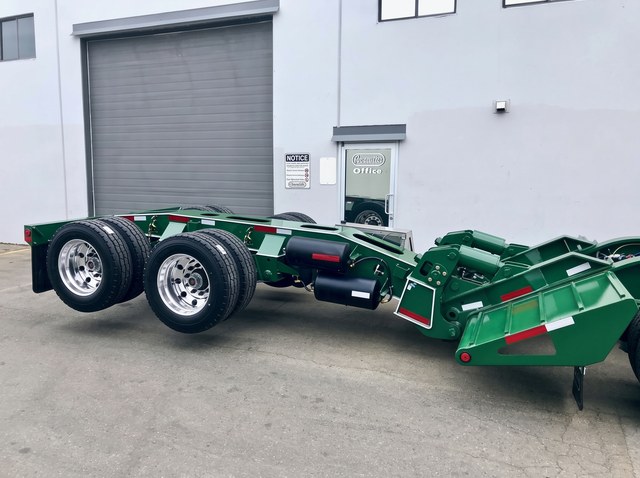 Close view of a green axle module, its coupling frame and polished wheels.