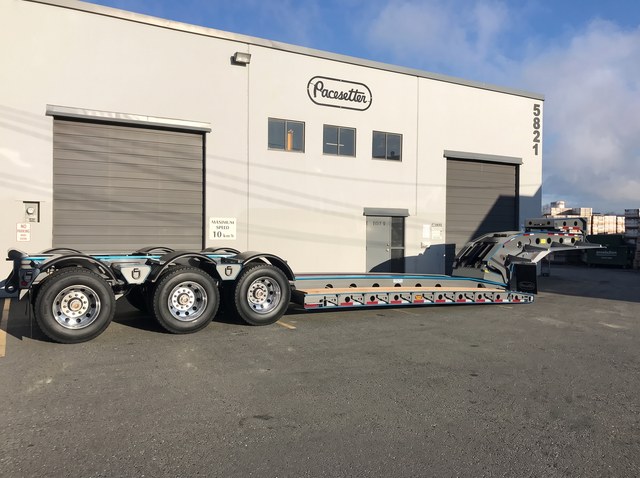 Side profile of the charcoal lowbed and its three rear axles in Langley.