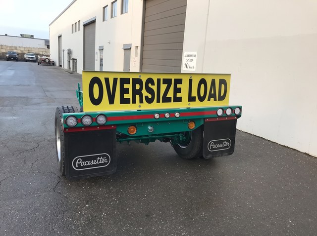Rear view of the green Fish Mouth booster and its Oversize Load sign.