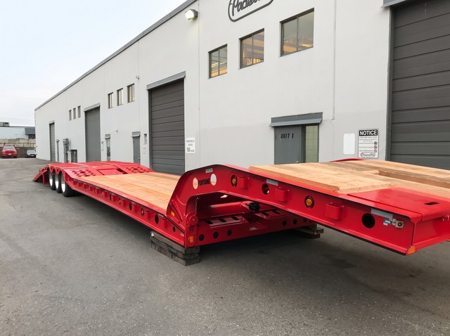 Close view of the red paving trailer gooseneck, frame and wooden deck.
