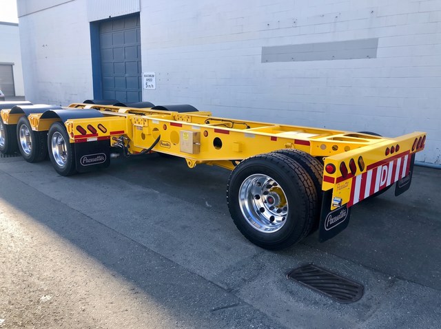 Yellow single-axle pin-on booster with the red-and-white D board.
