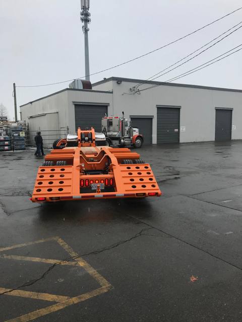 Orange tri-axle 55 ton lowbed with wood deck, hitched for winter delivery at the Pacesetter yard, photo 5 of 14