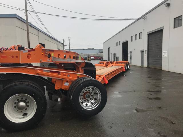 Orange tri-axle 55 ton lowbed with wood deck, hitched for winter delivery at the Pacesetter yard, photo 8 of 14