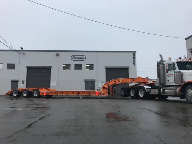 Orange tri-axle 55 ton lowbed with wood deck, hitched for winter delivery at the Pacesetter yard, photo 9 of 14