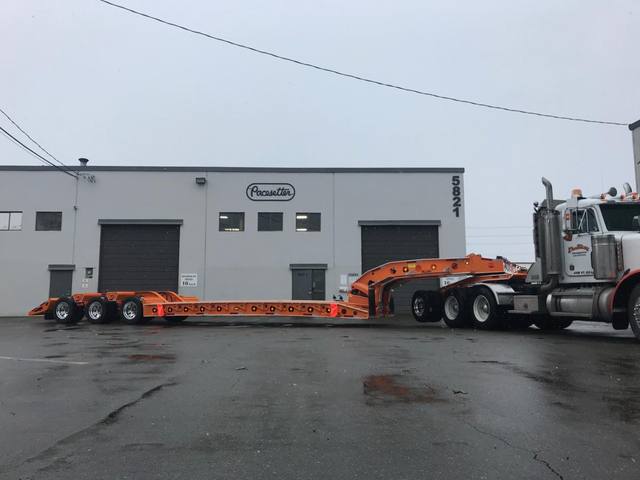 Orange tri-axle 55 ton lowbed with wood deck, hitched for winter delivery at the Pacesetter yard, photo 10 of 14