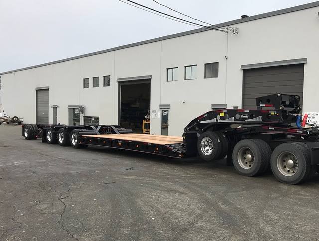 Black 55 ton lowbed with red pinstriping and a single axle pin-on booster at the Pacesetter yard, photo 12 of 14