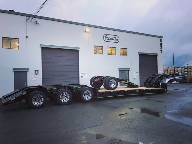 Black 55 ton lowbed with green pinstriping at dusk, booster axle carried on the deck, photo 2 of 2