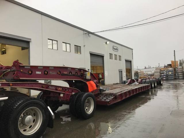 Burgundy 65 ton lowbed with matching Peterbilt tractor leaving the Pacesetter plant in the rain, photo 3 of 3