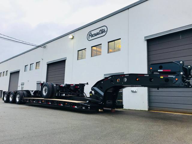 Gloss black 65 ton lowbed with polished aluminum wheels at dusk outside the Pacesetter plant, photo 1 of 6