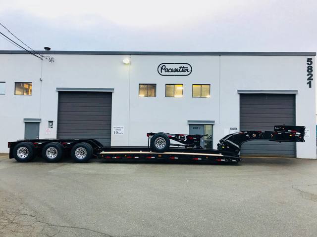 Gloss black 65 ton lowbed with polished aluminum wheels at dusk outside the Pacesetter plant, photo 3 of 6