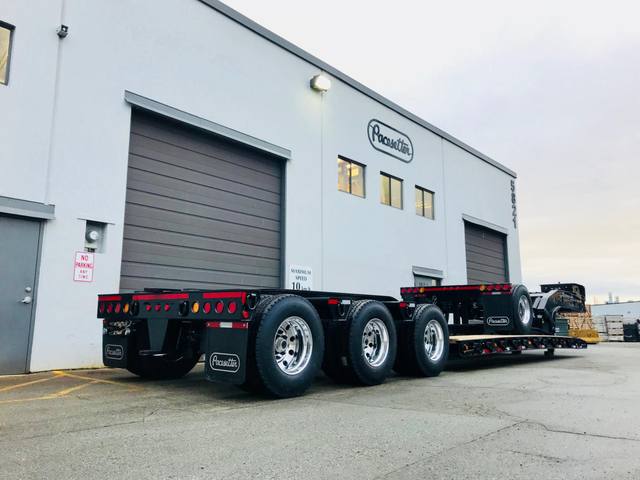 Gloss black 65 ton lowbed with polished aluminum wheels at dusk outside the Pacesetter plant, photo 4 of 6
