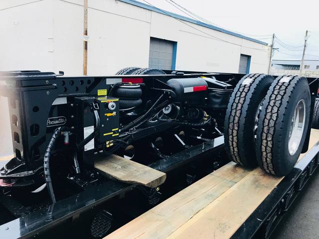 Gloss black 65 ton lowbed with polished aluminum wheels at dusk outside the Pacesetter plant, photo 6 of 6