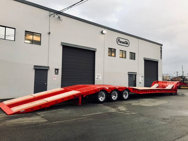 Red tri-axle paving trailer with hydraulic flip ramp at the Pacesetter plant, photo 7 of 18