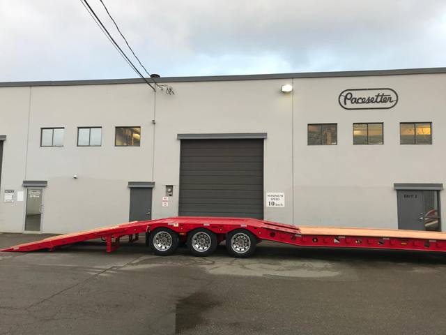 Red tri-axle paving trailer with hydraulic flip ramp at the Pacesetter plant, photo 8 of 18