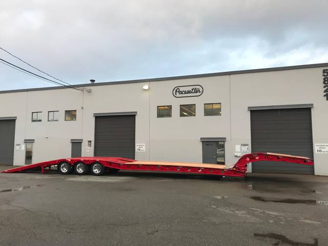 Red tri-axle paving trailer with hydraulic flip ramp at the Pacesetter plant, photo 9 of 18