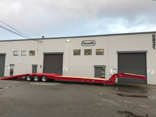 Red tri-axle paving trailer with hydraulic flip ramp at the Pacesetter plant, photo 10 of 18