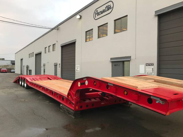 Red tri-axle paving trailer with hydraulic flip ramp at the Pacesetter plant, photo 13 of 18