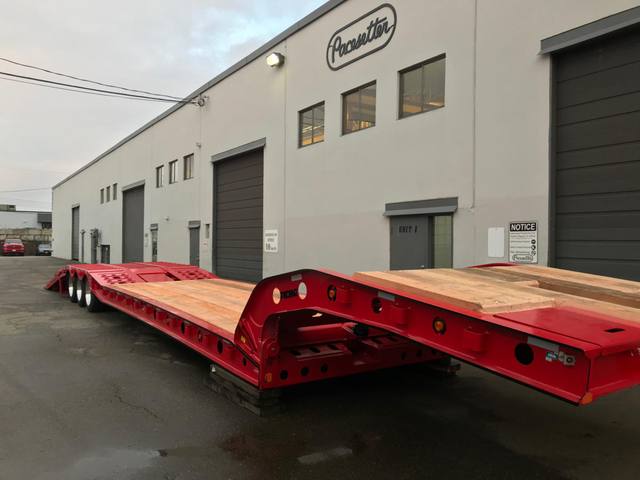Red tri-axle paving trailer with hydraulic flip ramp at the Pacesetter plant, photo 14 of 18