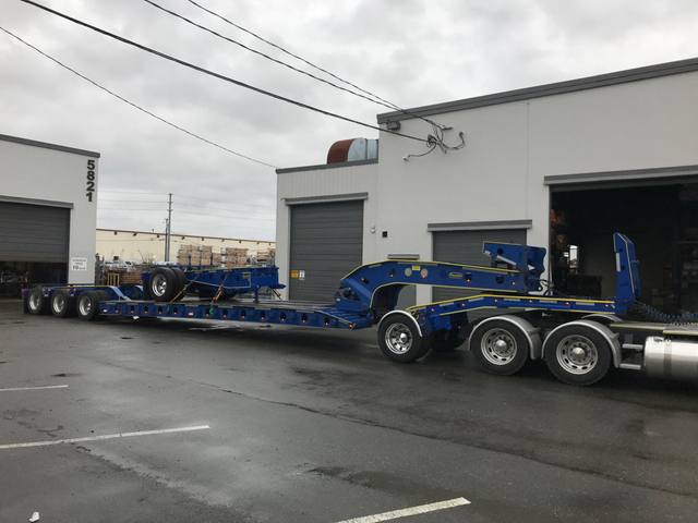 Blue trombone extension frame riding on the deck of a customer lowbed, photo 1 of 2