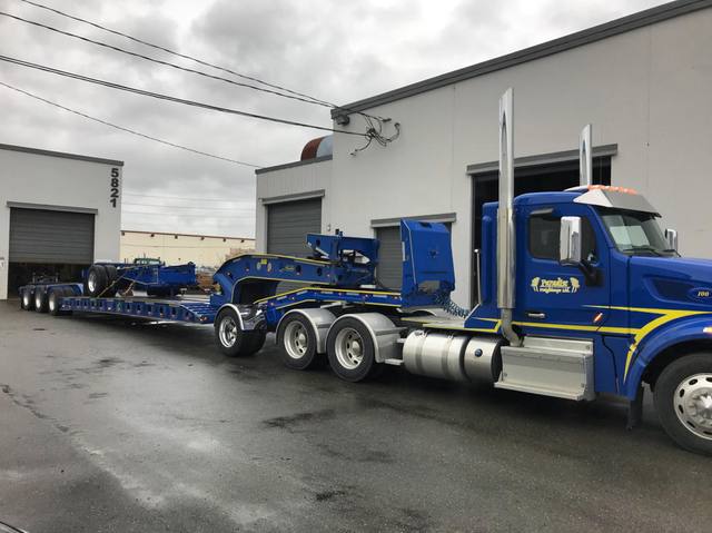 Blue trombone extension frame riding on the deck of a customer lowbed, photo 2 of 2